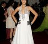 Rihanna no Met Gala 2007 com vestido branco de Georges Chakra, com cintura império, bordados prateados e luvas de arrastão pretas, em sua primeira aparição no evento