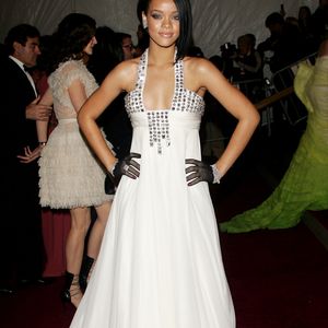 Rihanna no Met Gala 2007 com vestido branco de Georges Chakra, com cintura império, bordados prateados e luvas de arrastão pretas, em sua primeira aparição no evento