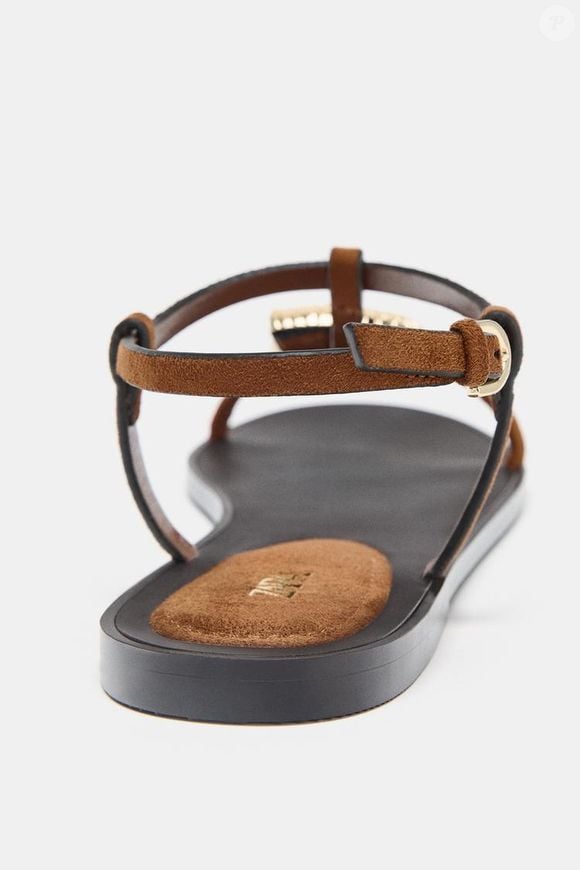 Com proposta versátil e elegante, essa rasteirinha aposta em uma tira frontal com aplicação metálica de concha como ponto de destaque. O modelo de  R$ 279,00 no site da Zara conta com fechamento no tornozelo por tira com fivela e acabamento em bico redondo, equilibrando simplicidade e sofisticação no dia a dia