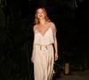 O look da ruiva é uma verdadeira viagem no tempo fashion ao combinar o romantismo boêmio dos anos 1970 com a sensualidade sofisticada dos slip dresses que marcaram a moda dos anos 1990
