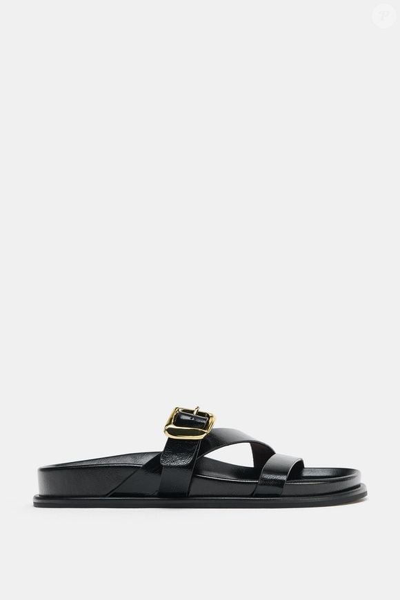 Inspirada na estética minimalista das criações de Yohji Yamamoto, a Zara apresenta uma sandália plana com tiras e detalhes de fivelas, uma opção versátil para diferentes produções