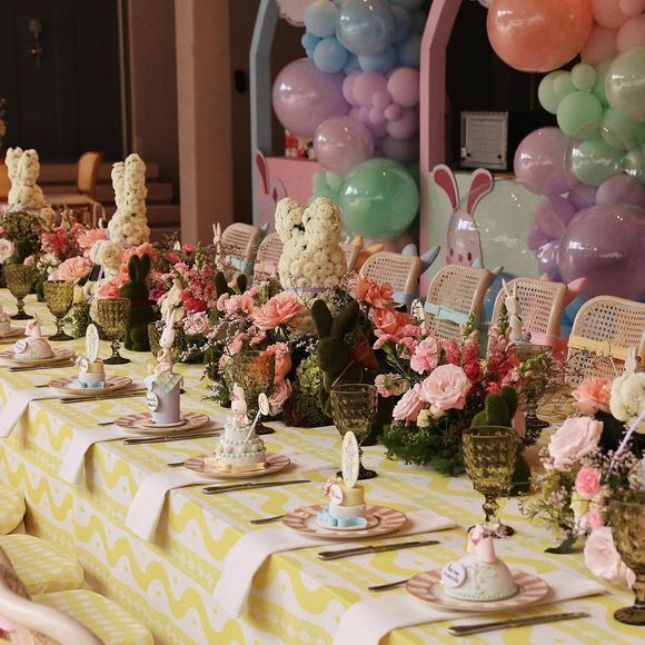 Detalhes da mesa principal, com flores, louças finas e toque artesanal nos enfeites.