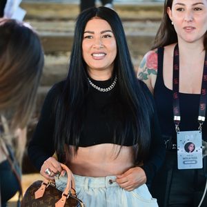 Simaria escolheu um look com top cropped preto, minissaia jeans volumosa e botas de cano alto