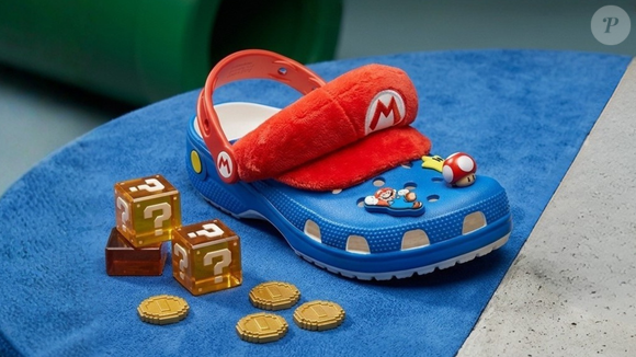 A Crocs Sandália Crocs Iam Mario Classic Clog Multi Multicolorido custa R$ 439,00 no Brasil e reúne elementos clássicos do personagem, como o boné vermelho de pelúcia, os botões amarelos do macacão e Jibbitz inspirados no universo de Super Mario