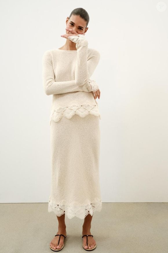 Saia Rústica de Crochê da Zara: Por R$ 229,00, o modelo na cor areia traz cintura média com elástico e aplicação de crochê na barra, reforçando a estética artesanal do boho chic. Para equilibrar a textura, uma regata branca ou cropped neutro cria um contraste elegante