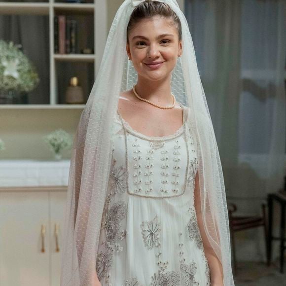 Novela 'Garota do Momento': Celeste (Débora Ozório) usa vestido de noiva com véu todo trabalhado, com colar de pérolas.