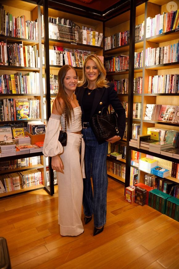 Ticiane Pinheiro elegeu uma produção com blazer e blusa pretos e uma calça jeans flare listrada