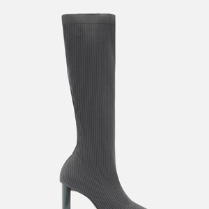 A Bota Skinny Cinza Knit Cano Longo Salto Bloco é confeccionada em tecido knit canelado, trazendo um visual moderno e fácil de combinar. Até o fechamento da matéria, o modelo aparecia por R$ 299,90 ou 3x de R$ 99,97 sem juros, segundo o site da Arezzo