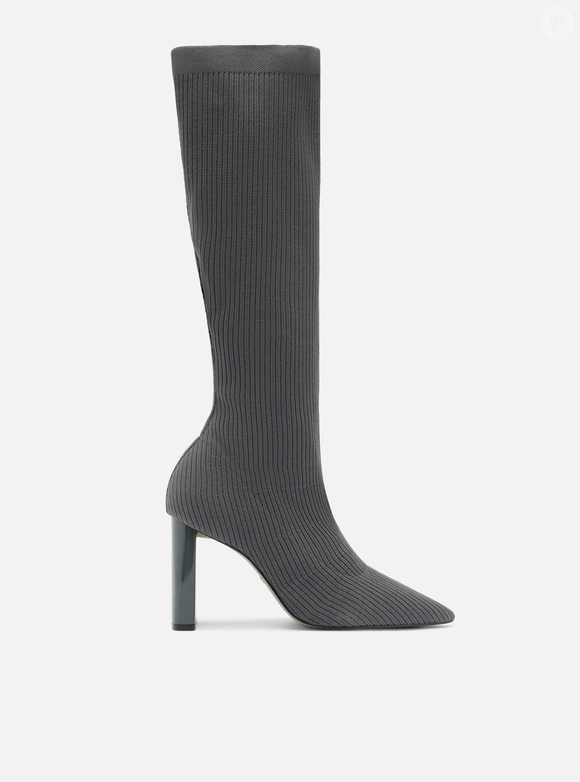 A Bota Skinny Cinza Knit Cano Longo Salto Bloco é confeccionada em tecido knit canelado, trazendo um visual moderno e fácil de combinar. Até o fechamento da matéria, o modelo aparecia por R$ 299,90 ou 3x de R$ 99,97 sem juros, segundo o site da Arezzo