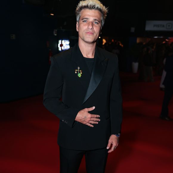 Bruno Gagliasso apostou em uma elegância clássica com um toque de modernidade ao surgir com um terno preto de corte impecável e lapela de cetim. O diferencial da produção ficou por conta do broche dourado com detalhes em verde posicionado na lapela, que quebrou a sobriedade do visual 'all black'