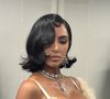 O visual ganhou ares de diva do cinema clássico graças ao penteado chanel solto, com risca lateral e mechas caídas que emolduravam o rosto, evocando o glamour dos anos 1950.