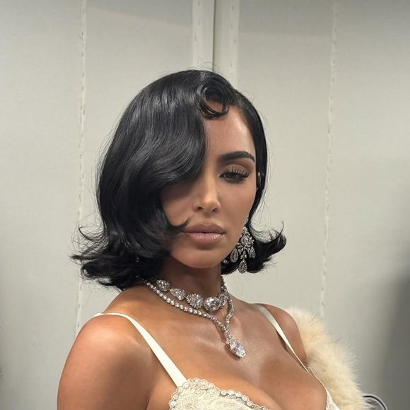 O visual ganhou ares de diva do cinema clássico graças ao penteado chanel solto, com risca lateral e mechas caídas que emolduravam o rosto, evocando o glamour dos anos 1950.