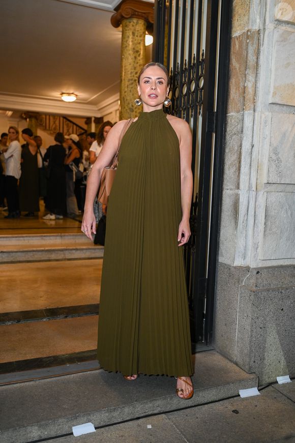 Exalando uma elegância escultural e orgânica, Juliana Silveira optou por um longo em tom verde-oliva profundo, uma das apostas cromáticas da temporada. O vestido apresenta um plissado vertical meticuloso que alonga a silhueta, com uma gola halter alta que deixa os ombros à mostra, evocando uma sofisticação minimalista