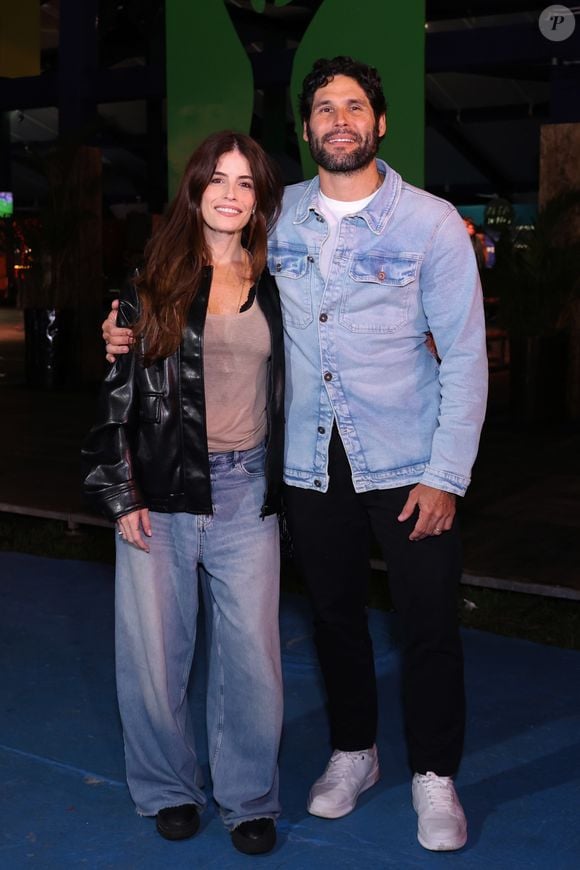 Fernanda Mader e Dudu Azevedo: Fernanda combinou uma regata básica bege texturizada sob uma jaqueta de couro preta robusta, finalizando com calça jeans wide leg de lavagem clara e sapatos escuros. Ao seu lado, Dudu seguiu a linha casual com uma jaqueta jeans de lavagem clássica sobre camiseta branca, calça preta de corte reto e tênis brancos