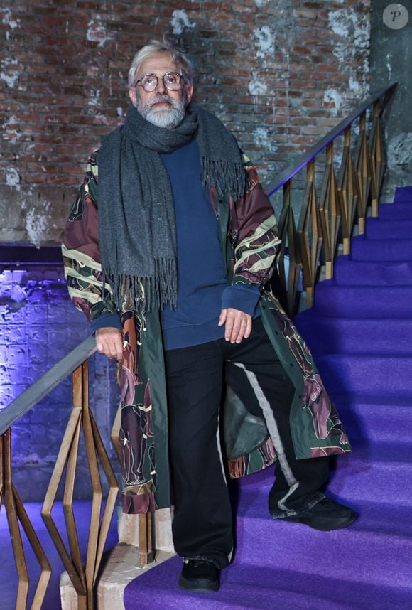 Paulo Borges apostou em um look marcado por sobreposições e estampas para prestigiar o evento fashion em São Paulo. O empresário combinou uma blusa azul-marinho e calça preta com um longo casaco estampado em tons de verde, vinho e bege, finalizando a produção com cachecol cinza e sapatos pretos