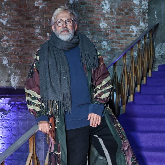 Paulo Borges apostou em um look marcado por sobreposições e estampas para prestigiar o evento fashion em São Paulo. O empresário combinou uma blusa azul-marinho e calça preta com um longo casaco estampado em tons de verde, vinho e bege, finalizando a produção com cachecol cinza e sapatos pretos