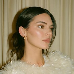 Kendall Jenner surgiu recentemente com um coque baixo e solto, risca central e uma mecha longa deixada propositalmente à mostra de um lado do rosto.