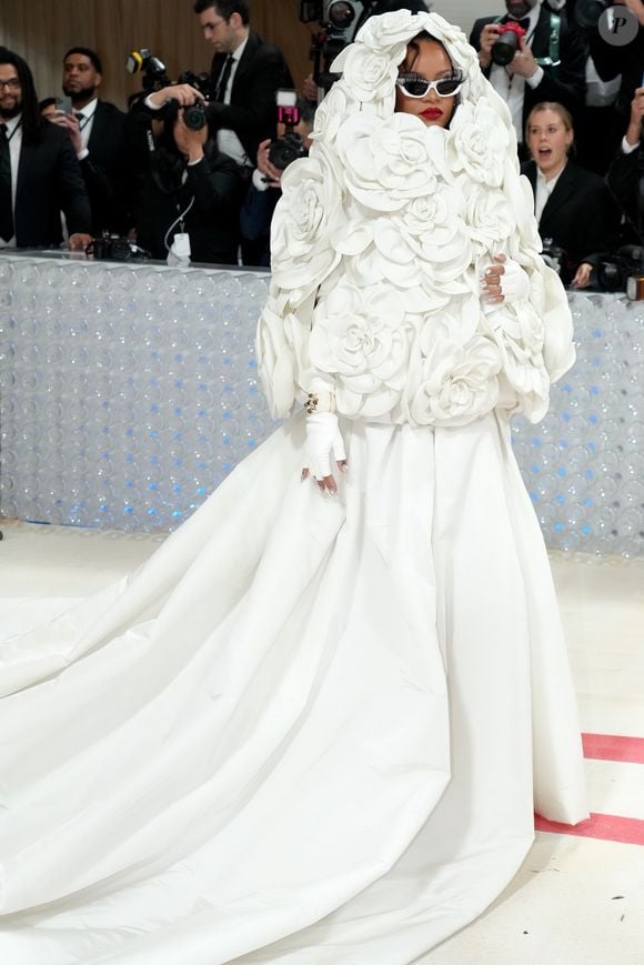 Rihanna no Met Gala 2023 com look branco da Valentino, com capa de flores camélia tridimensionais