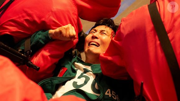 Gi-hun, desesperado, pede para ser morto pelos guardas, mas continua no jogo por punição