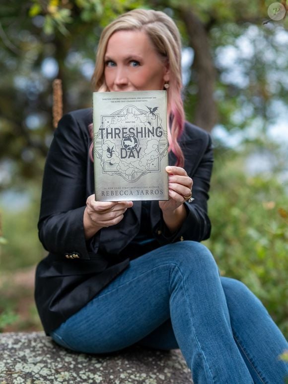 A autora Rebecca Yarros com 'Dia da Ceifa' (Threshing Day, no original em inglês), livro de contos que reúne 13 novas histórias ambientadas no universo de 'Quarta Asa'