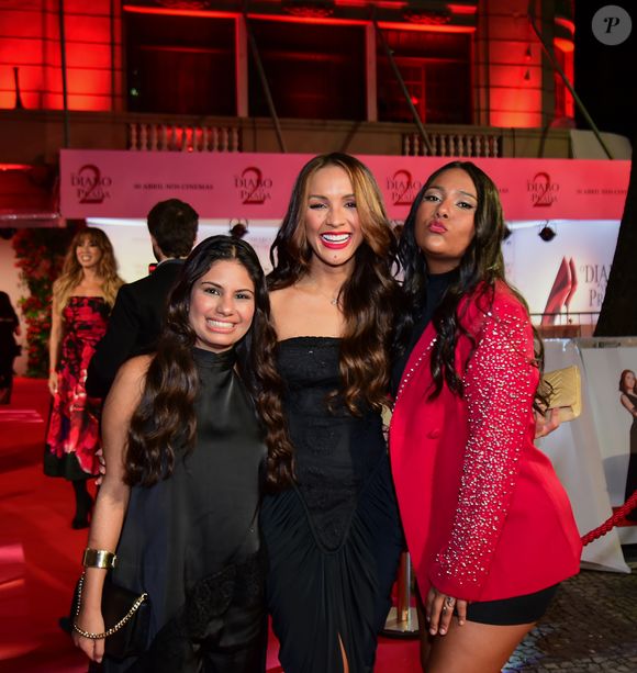 Gabi, Maxiane e Chaiany juntas, com diferentes estilos: a 'panquequinha' usou um vestido preto de gola alta e acabamento acetinado; já Chai um blazer vermelho vibrante com lapelas e mangas inteiramente cravejadas de cristais, sobreposto a uma base preta minimalista