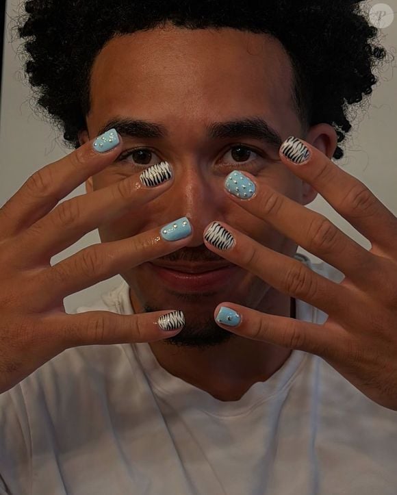 Para quem realmente gosta de unhas chamativas, o Animal Print + Aplicações 3D mistura estampa de zebra em preto e branco com fundo azul bebê e aplicações de pedrarias prateadas metálicas. A combinação une uma estampa clássica a detalhes tridimensionais e cria uma composição rica em textura e impacto.