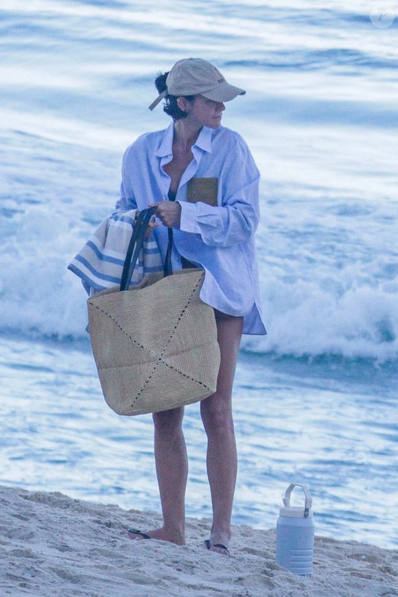 Com bolsa de palha e boné bege, Bruna Marquezine apostou em um visual leve para o dia de praia