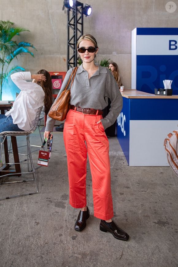 A atriz Valentina Herszage foi destaque ao circular pelo evento Rio2C apostando em uma variação autêntica do estilo corpcore. Fugindo da paleta tradicional de cinzas e pretos, Valentina combinou uma polo de tricô texturizada com calças de alfaiataria em tom coral vibrante
