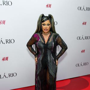 Gloria Groove entregou uma produção dramática e cheia de texturas, centrada em um vestido longo transparente de tule preto com padrões geométricos e detalhes em tons de roxo e verde. Por baixo da peça fluida, Gloria utilizou um conjunto de hot pants e top pretos. O visual foi enriquecido com colares de correntes sobrepostos, incluindo um pingente de cruz, e uma maquiagem marcante com delineado gráfico