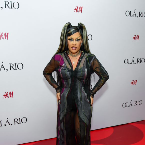 Gloria Groove entregou uma produção dramática e cheia de texturas, centrada em um vestido longo transparente de tule preto com padrões geométricos e detalhes em tons de roxo e verde. Por baixo da peça fluida, Gloria utilizou um conjunto de hot pants e top pretos. O visual foi enriquecido com colares de correntes sobrepostos, incluindo um pingente de cruz, e uma maquiagem marcante com delineado gráfico
