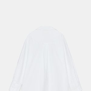 A Camisa Básica Oxford da Zara aposta em uma construção clássica com fio de algodão, gola de lapela, decote V e mangas amplas, além de fechamento frontal por botões