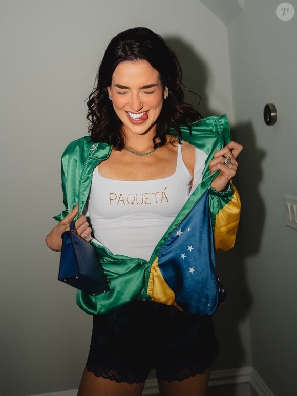 Duda Fournier também homenageou o marido, Lucas Paquetá, com uma camiseta branca. Para compor o look, a influenciadora usou um short preto e jaqueta com a estampa do Brasil