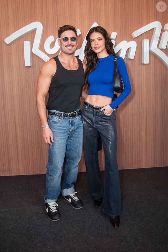 Daniel Rocha escolheu regata preta com jeans azul de modelagem reta e tênis esportivos, enquanto Vitória Strada usou uma calça flare de couro e um cropped azul royal de manga comprida