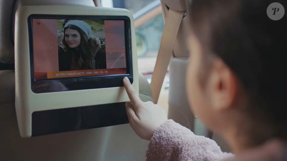 Filha de Bahar, Nisan pede para ver TV no carro e encontra matéria sobre a morte de Yeliz, porém não consegue escutar a reportagem na novela 'Força de Mulher' na segunda-feira, 17 de fevereiro de 2025