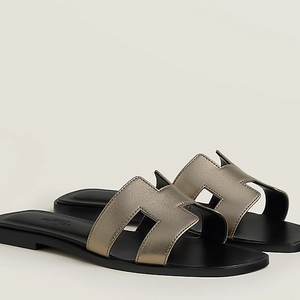 Inspiradas nos modelos icônicos da Hermès, as sandálias estilo 'slide' seguem como uma das maiores tendências da estação e dominam os looks minimalistas da estação