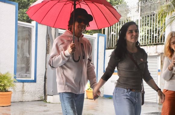 Mesmo na chuva, Djavan vota; cantor se protege com guarda-chuva vermelho ao exercer papel de cidadão