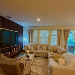 A sala de estar da mansão de Rick Sollo, da dupla com Renner, conta com dois sofás e uma poltrona, distribuídos em dois ambientes. A decoração segue uma proposta clássica, com tons neutros que aparecem em diferentes cômodos da propriedade