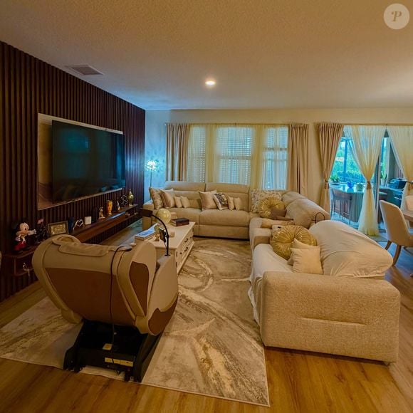 A sala de estar da mansão de Rick Sollo, da dupla com Renner, conta com dois sofás e uma poltrona, distribuídos em dois ambientes. A decoração segue uma proposta clássica, com tons neutros que aparecem em diferentes cômodos da propriedade