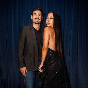 Sabrina Sato apostou num vestido longo preto exuberante com brilhos e pedrarias reluzentes espalhadas por toda a peça. O modelo destaca-se pelas costas totalmente descobertas e por um caimento fluido com cauda leve. Nos acessórios, optou por brincos redondos prateados bem marcantes, pulseiras delicadas e anéis brilhantes, além de manicura com unhas escuras compridas