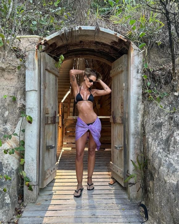 Em uma viagem recente, a modelo destacou seu corpo com uma canga roxa e biquíni preto