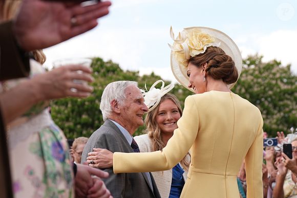 A Princesa Kate Middleton cumprimentou os convidados de forma radiante. Ela apostou em um chapéu com detalhe de flores, e seu cabelo estava arrumado em um coque trabalhado.