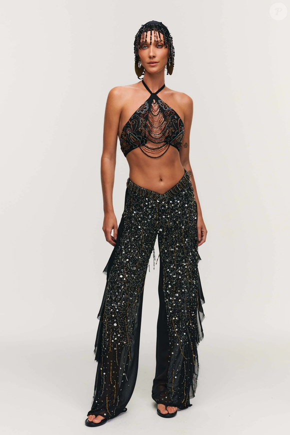Headpiece, peça que ganhou destaque no Carnaval, combina perfeitamente com a estética boho chic. Para completar o visual, a calça pantalona em chiffon preta surge como aposta elegante: tem babado lateral, cós em formato de V e modelagem ampla, da marca Hisha é uma aposta para o Lollapalooza 2026