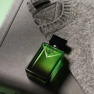 O frasco do Prada Paradigme chama atenção logo de cara com seu degradê em preto e verde, acabamento inspirado no couro Saffiano e o icônico triângulo inclinado da maison italiana