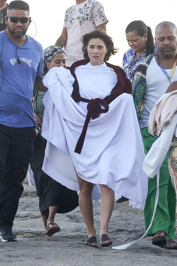 Carolina Dieckmann grava cenas da adaptação de A Viagem na Praia da Macumba, no Rio de Janeiro, usando figurino branco e etéreo que remete ao plano espiritual de Diná