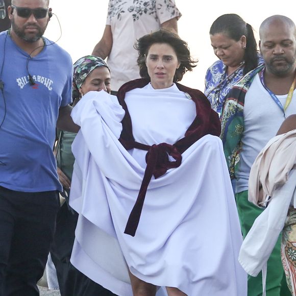 Carolina Dieckmann grava cenas da adaptação de A Viagem na Praia da Macumba, no Rio de Janeiro, usando figurino branco e etéreo que remete ao plano espiritual de Diná