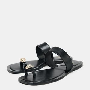 Nova aposta da Zara! Sandália rasteira de R$ 249 surpreende com design que foge do óbvio e aposta em tira que sustenta o peito do pé e o dedão, em uma estética boho sofisticada com detalhe de concha metálica