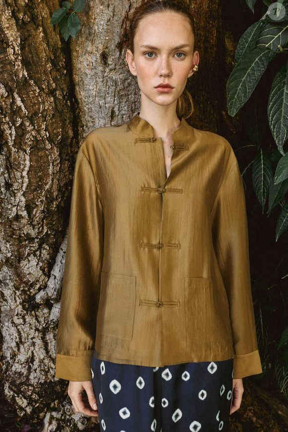 A camisa acetinada aparece renovada para a Primavera 2026 com mangas amplas, bolsos de patch e fechamento frontal por alamares, detalhe que acrescenta um toque artesanal à peça. O modelo da Zara está disponível em mostarda, azul-marinho, rosa-pastel e branco. Custa R$ 279