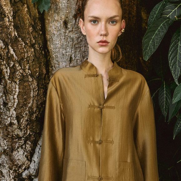 A camisa acetinada aparece renovada para a Primavera 2026 com mangas amplas, bolsos de patch e fechamento frontal por alamares, detalhe que acrescenta um toque artesanal à peça. O modelo da Zara está disponível em mostarda, azul-marinho, rosa-pastel e branco. Custa R$ 279
