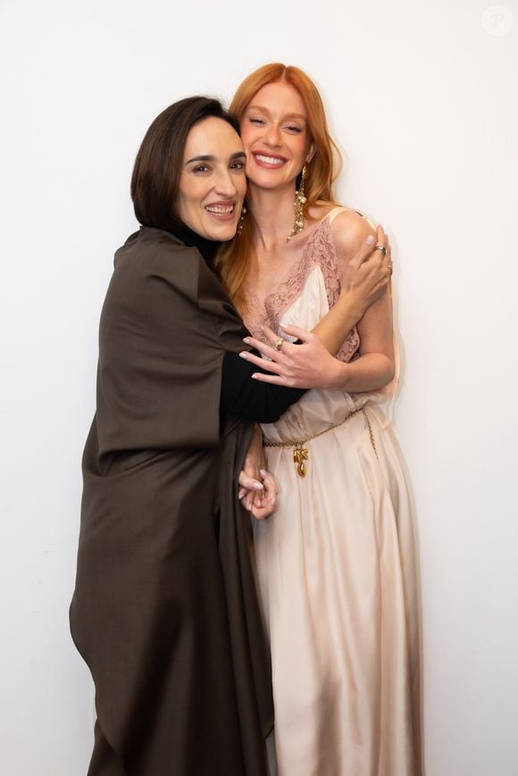 O cinto de corrente com berloques usado pela atriz acrescenta ao look uma referência aos anos 90, enquanto os brincos de pérolas e correntes reforçam o glamour boho associado aos anos 70. A atriz posou ao lado da jornalista Maria Prata