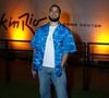Francisco Gil escolheu uma camisa azul estampada sobre camiseta branca, combinada a jeans largo, tênis e acessórios prateados